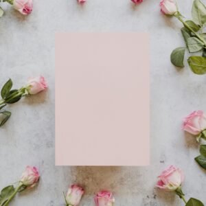 a sheet of paper surrounded by pink roses